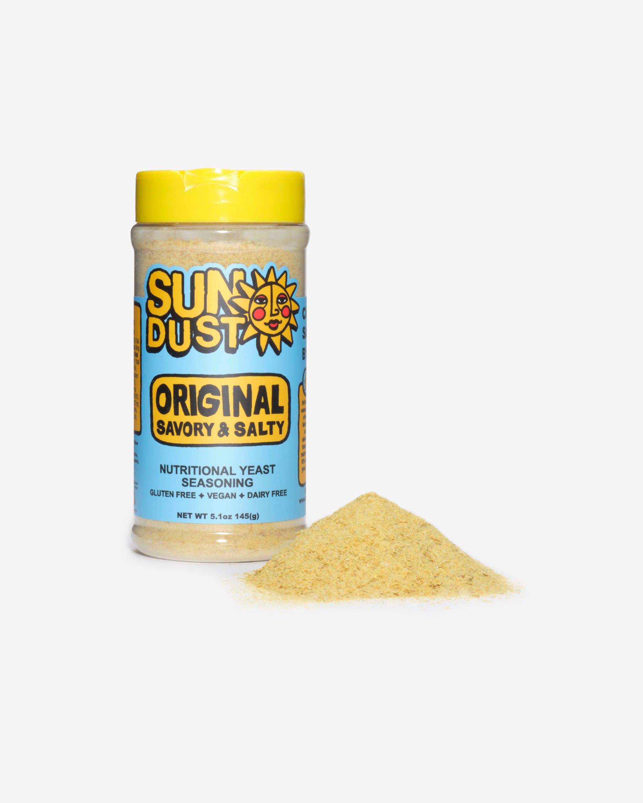 Sun Dust Original jar beside a mound of golden nutritional yeast seasoning